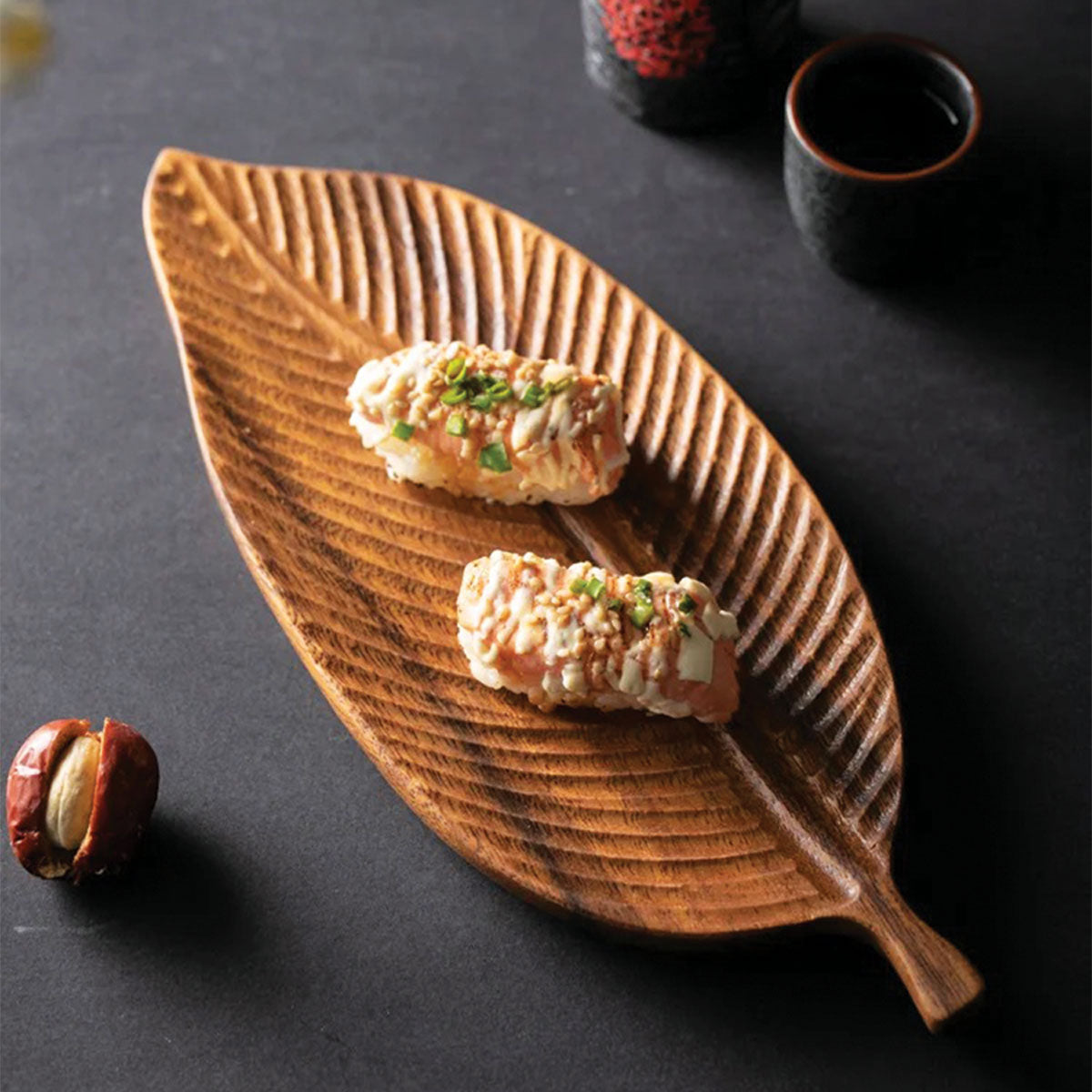 Skål gjord av mörkt valnötsträ med löv